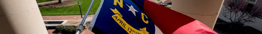A North Carolina state flag waves in the wind.