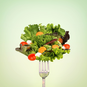 A fork with a bouquet of lettuce and vegetables.